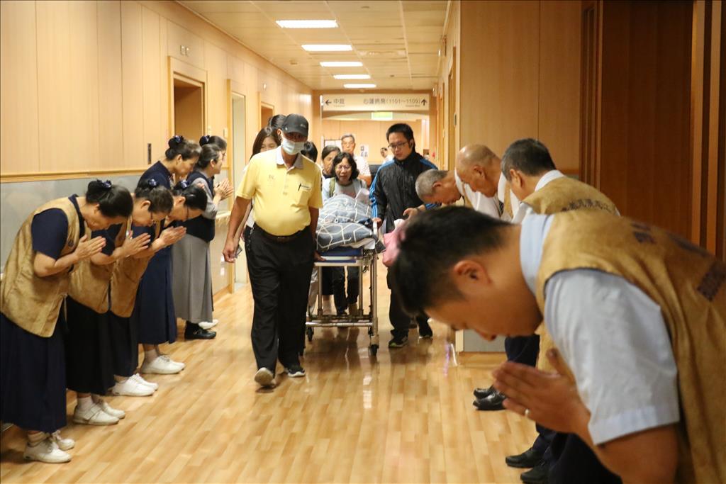 醫院志工恭敬合十,送陳先生去花蓮當大體老師。(台中慈濟醫院提供)