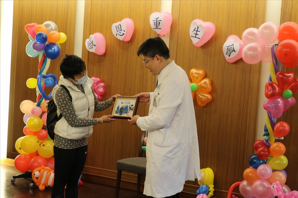 外科部主任余政展(右 )將葳葳的手術搶救圖送給媽媽,成為最特別的禮物。