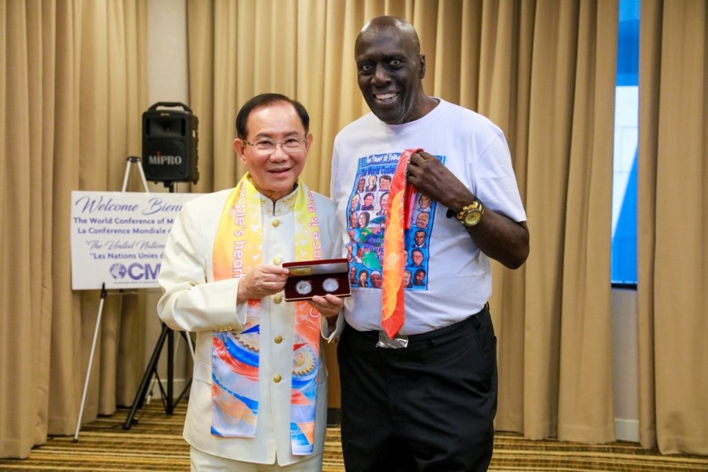▲洪博士致贈紀念銀幣給前哈林環球旅行者籃球明星Bobby Hunter。(記者李欣翻攝)