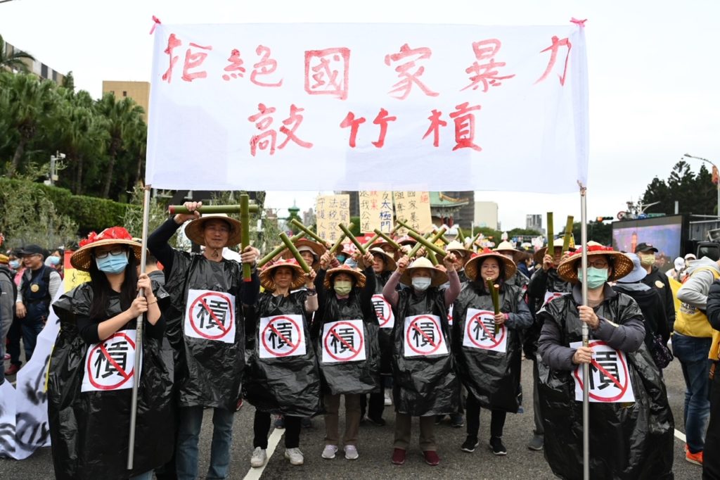 ▲民眾帶著斗笠沿途敲打「竹槓」,抗議無良官員「敲竹槓」,呼籲良心官員,違法官員關起來、撤銷違法強制執行、歸還太極門修行聖地。(記者晨曦翻攝)