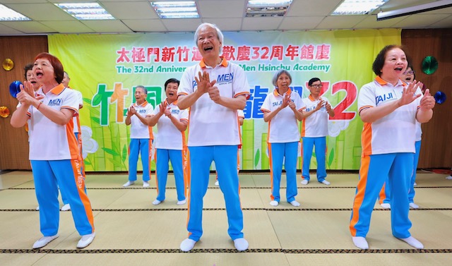 ▲83歲的簡瑞明師兄(中)表示,因為得師父指點練功得到健康,透過手語展演傳送和平心氣,希望大家能夠回到幸福的心靈故鄉。(記者李欣翻攝)